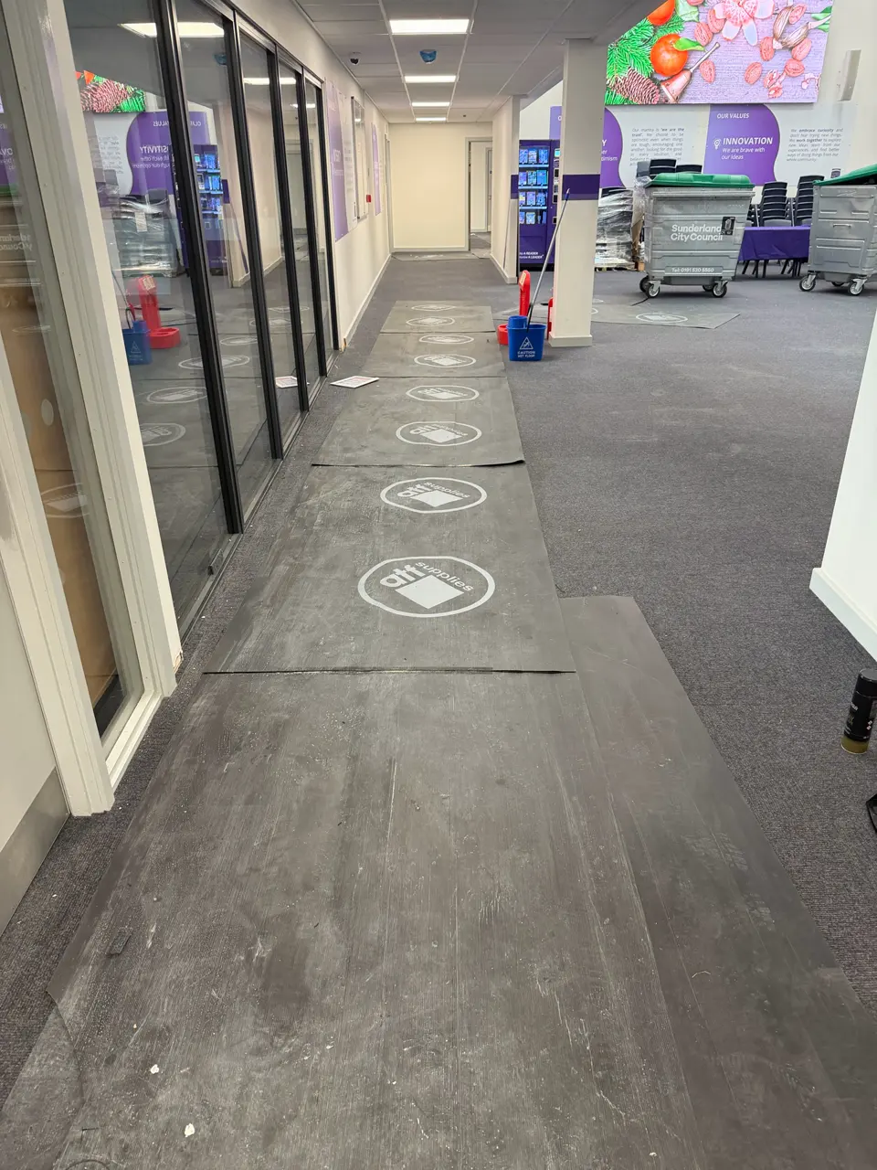 Commercial interior prepared for builders cleaning, with temporary floor protection and post-construction dust