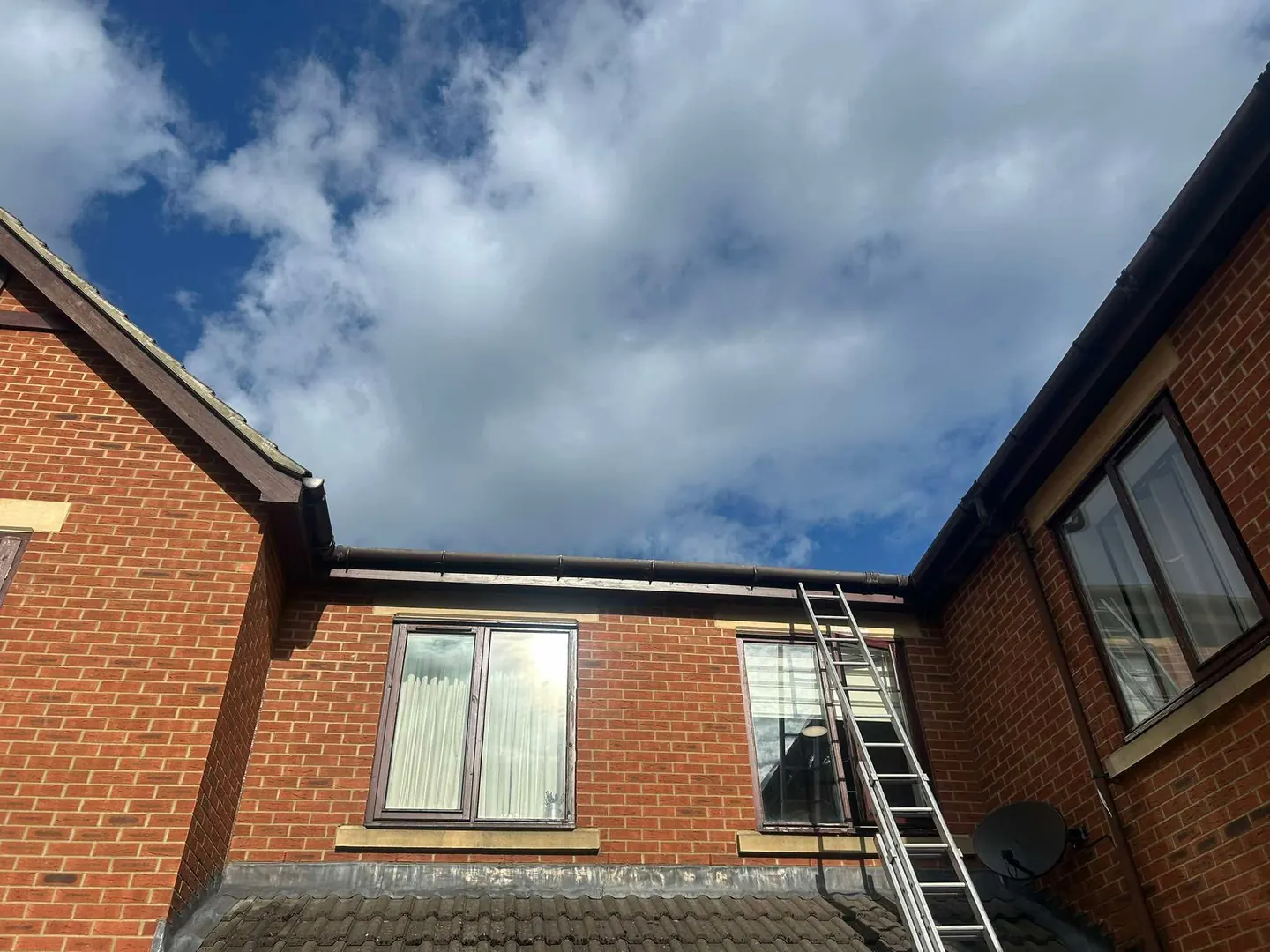 Gutter clearing work at a brick care-home building