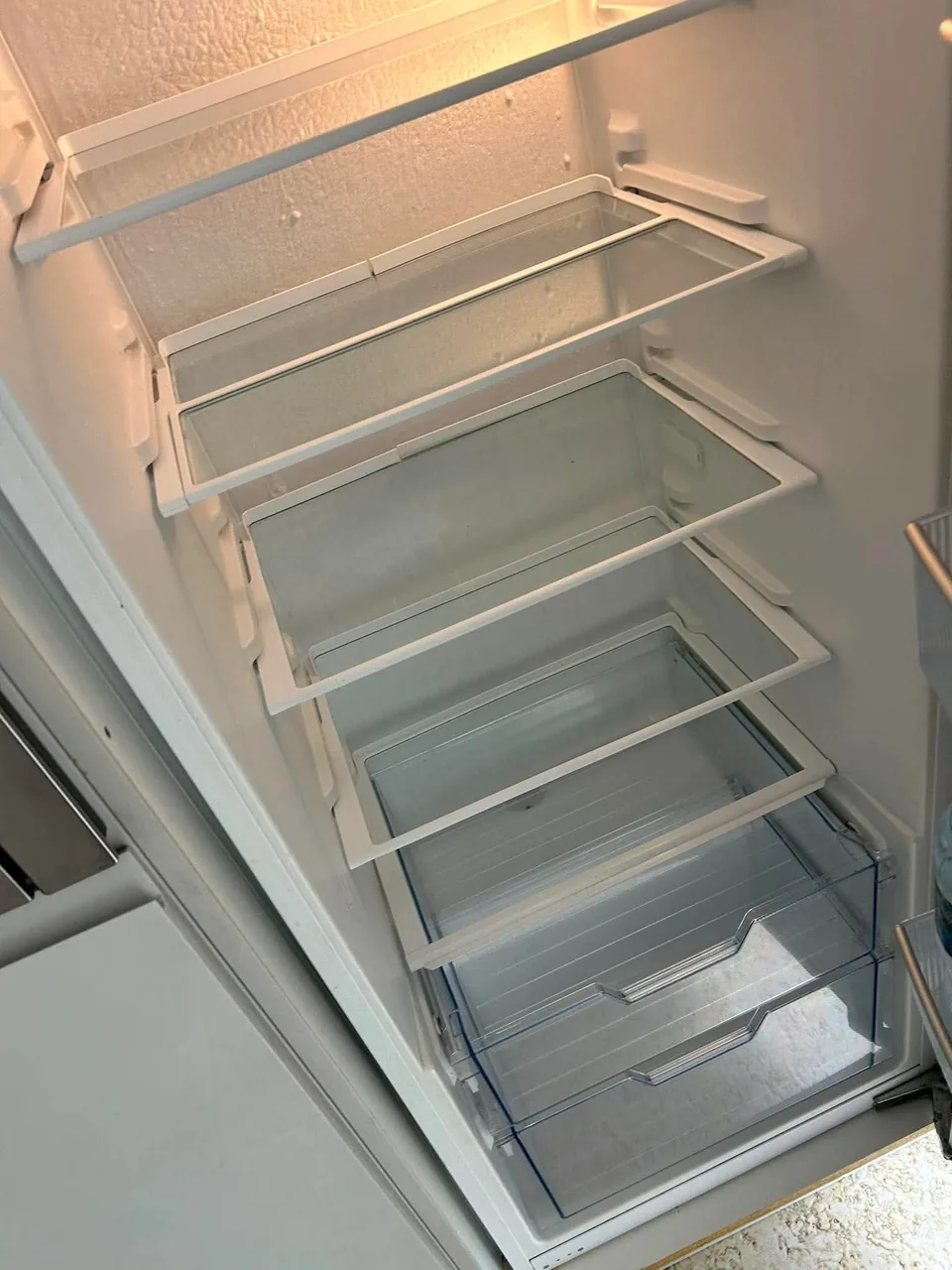 Clean empty domestic refrigerator prepared during a detailed property clean