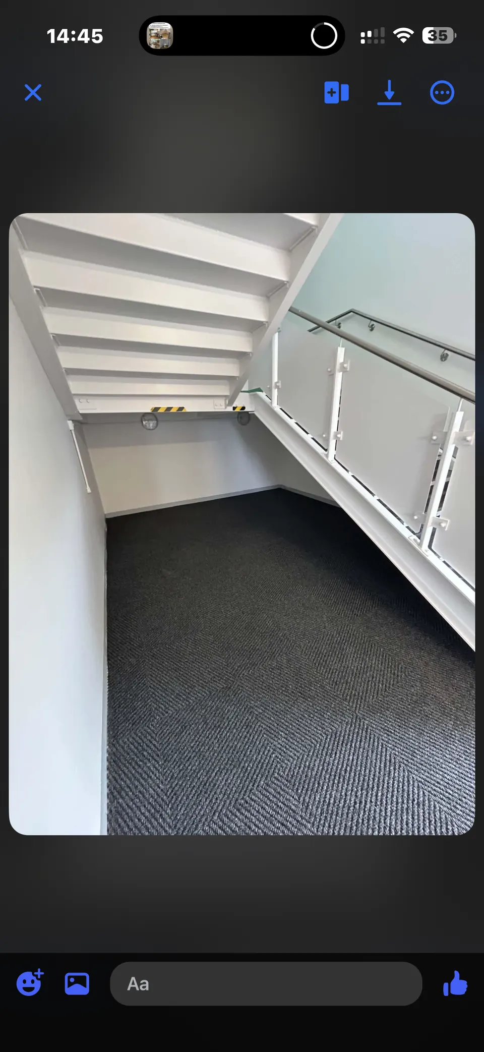 Clean school stairwell with white structure, glazed balustrade and dark carpeted landing