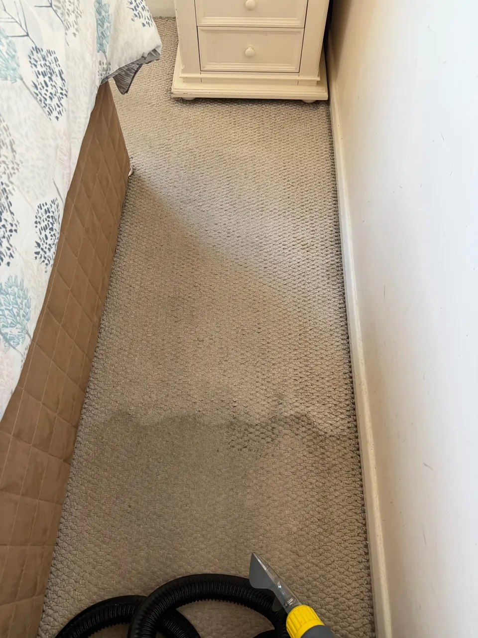 Residential bedroom carpet being cleaned with extraction equipment