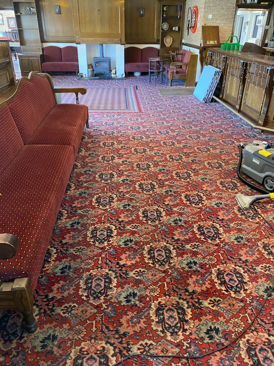 Completed commercial pub lounge carpet with seating and cleaning equipment