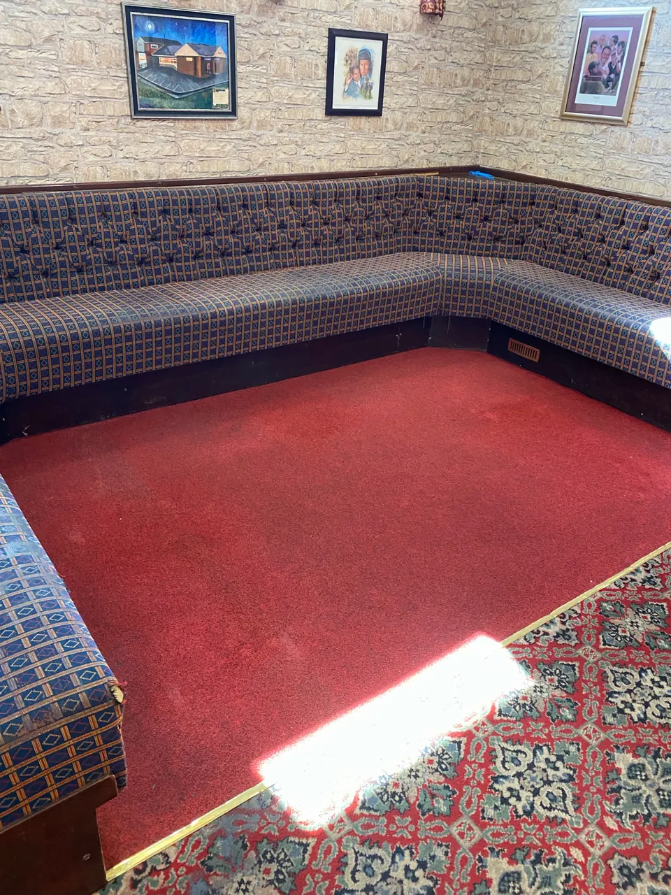 Red-carpeted pub seating area with patterned upholstery