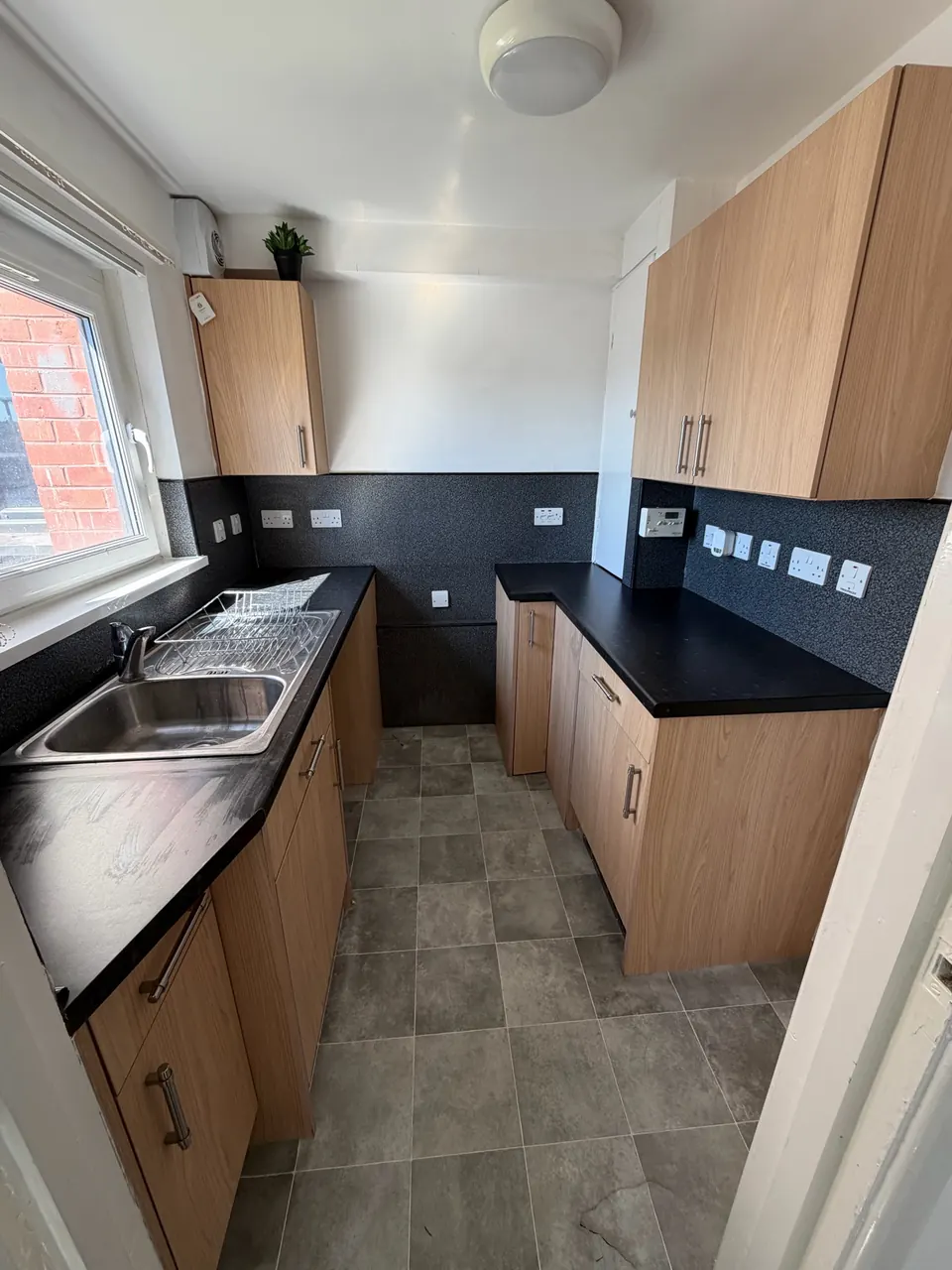 Clean residential kitchen with detailed surfaces and cupboards