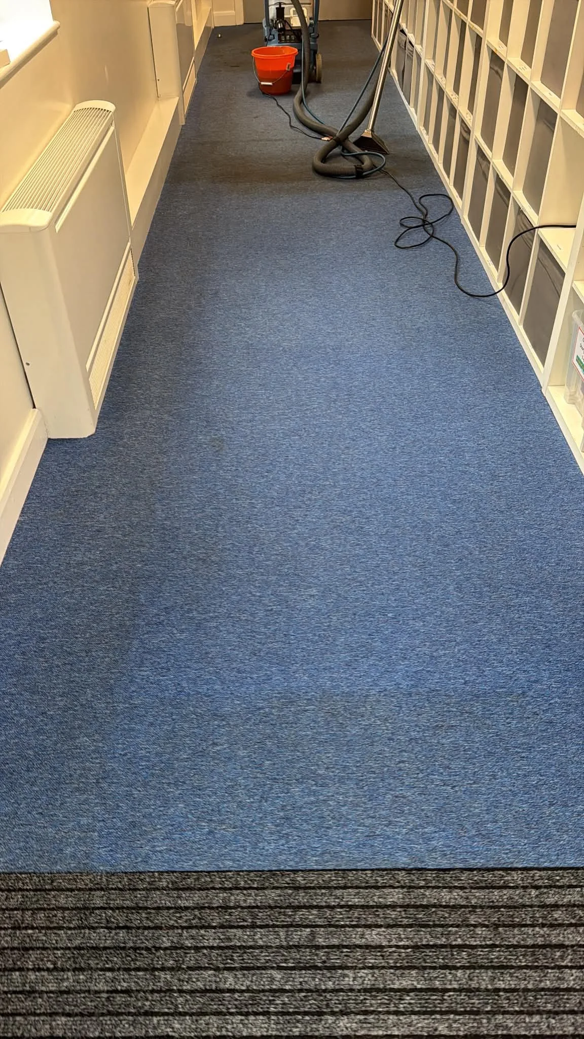 Carpet-cleaning equipment in use along a high-footfall school corridor