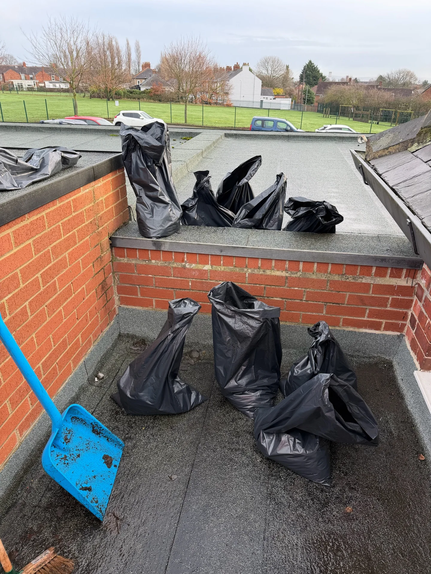 Bagged clearance material on the roof at a school roof-and-gully cleaning project